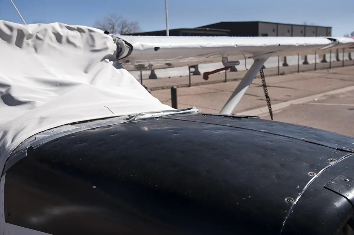 Motorhaube einer Cessna mit vielen kleinen Hagelbeulen